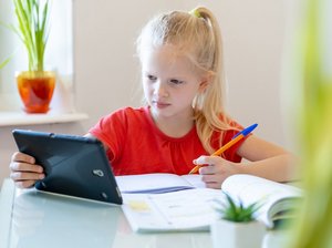 Home Schooling, Foto: Adobe Stock/Natalya Kuzina Ein Kind lernt mit Tablet