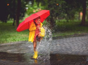 Kinder lernen Natur spielerisch kennen, Foto: Adobe Stock/Atamamenko Kind spielt im Regen